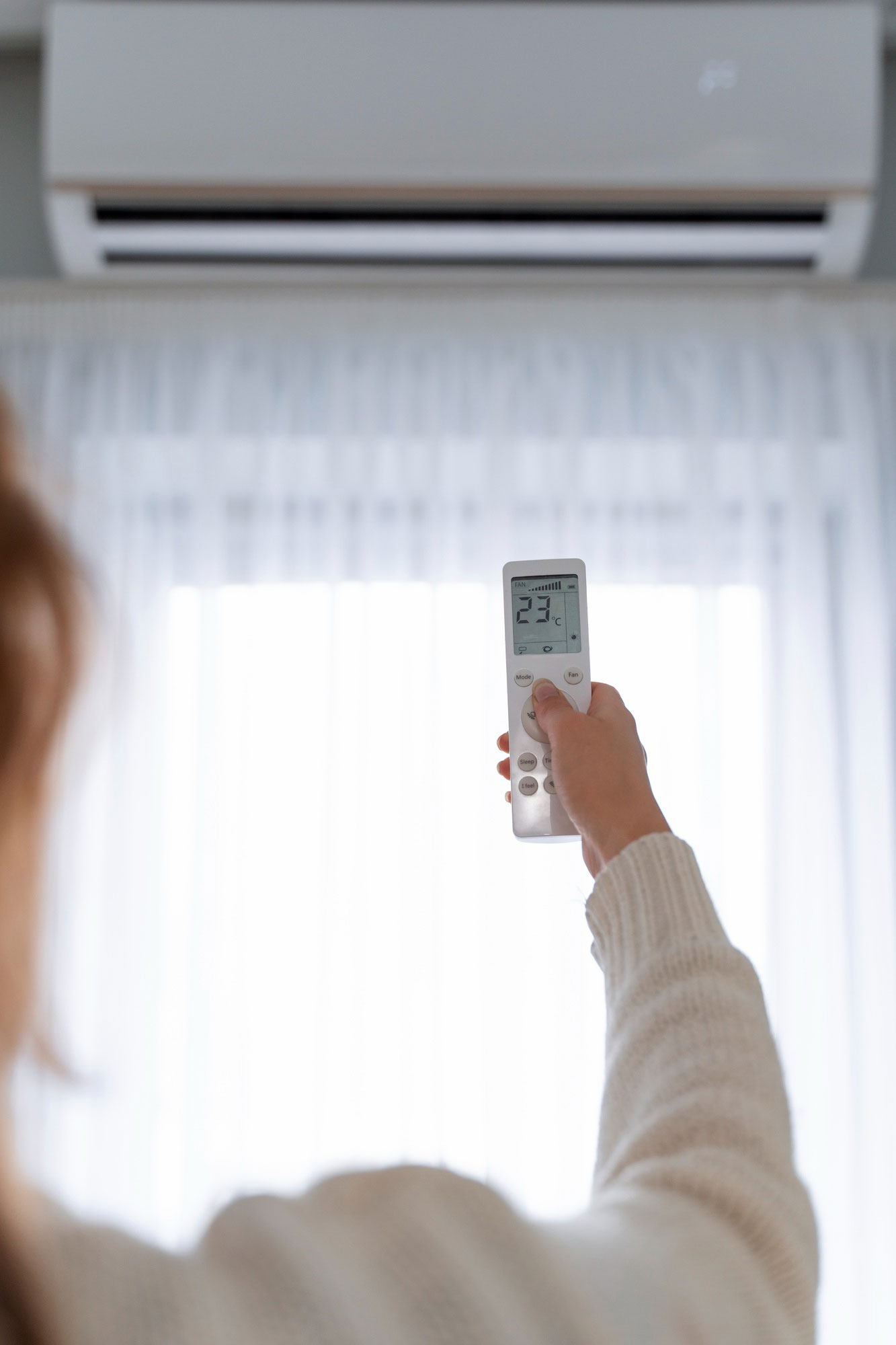 Picture of a Woman Holding an Air Conditioner Remote