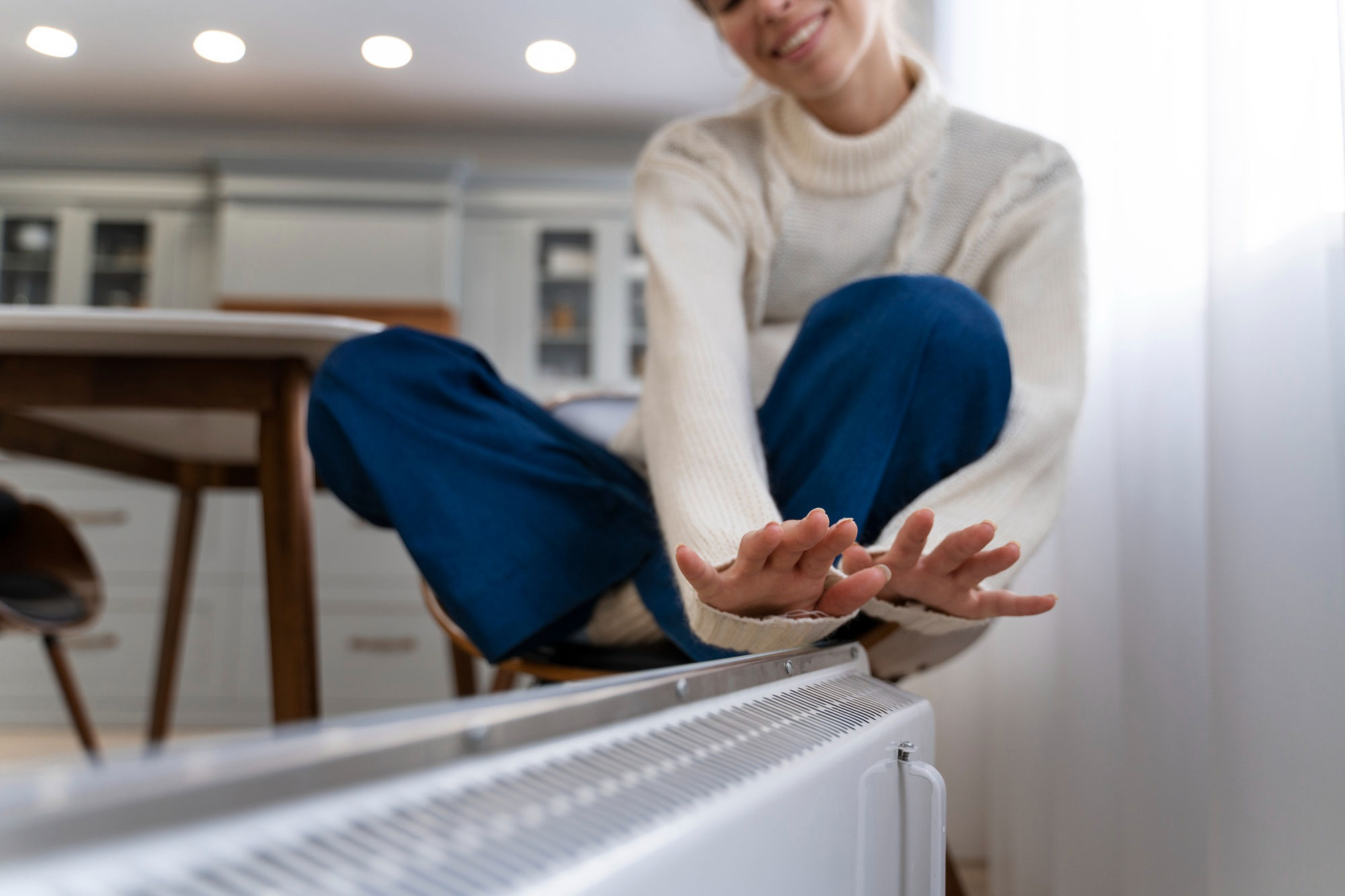 Picture of a Woman Warming Her Hands Near a Heater